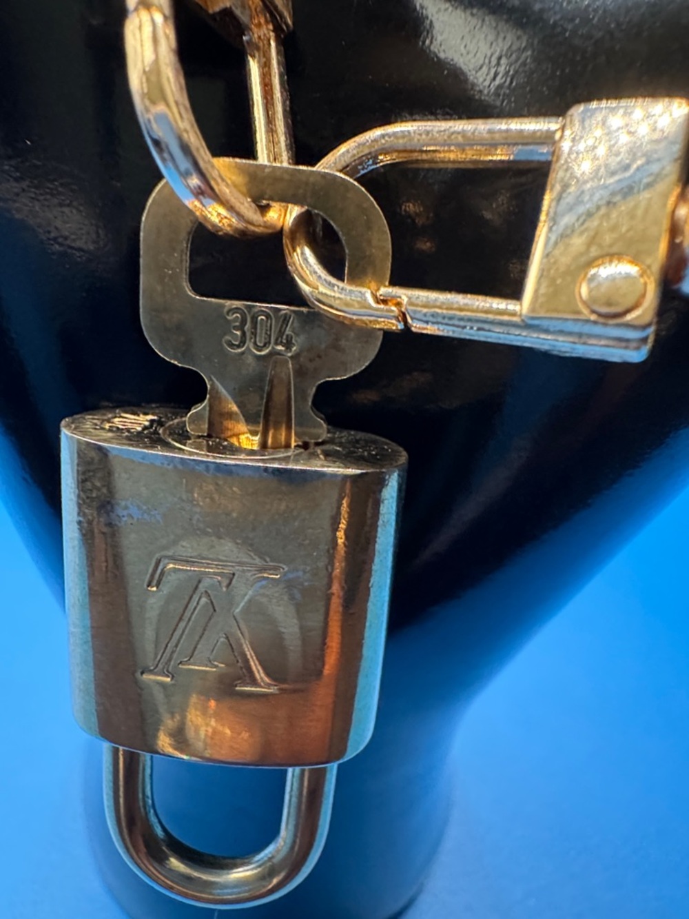 Louis Vuitton Gold-tone LV Initial Padlock and Key Charm On an Unbranded Bracet.